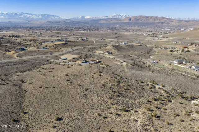 a view of a dry field with mountains in the background