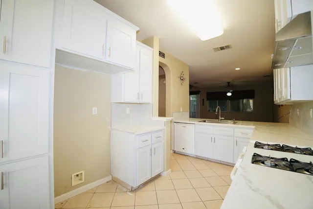 a kitchen with white cabinets and appliances
