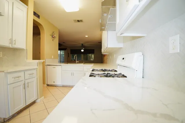 a kitchen with white cabinets and appliances