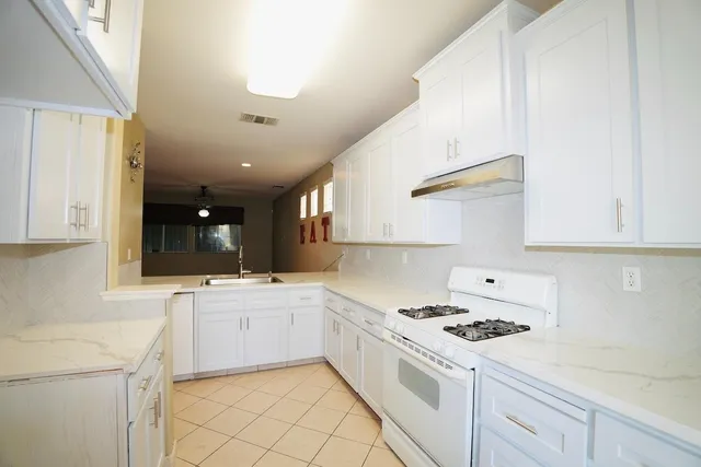 a kitchen with a stove a sink and a refrigerator