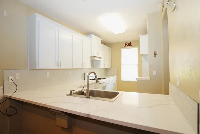 a kitchen with a sink a window and cabinets