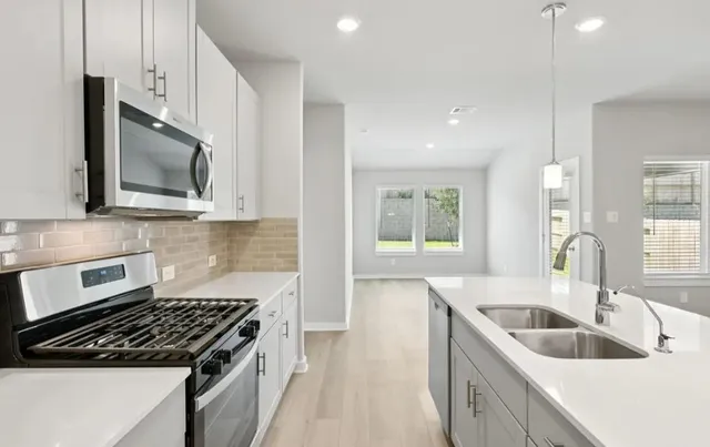 a kitchen with stainless steel appliances granite countertop a sink stove and microwave
