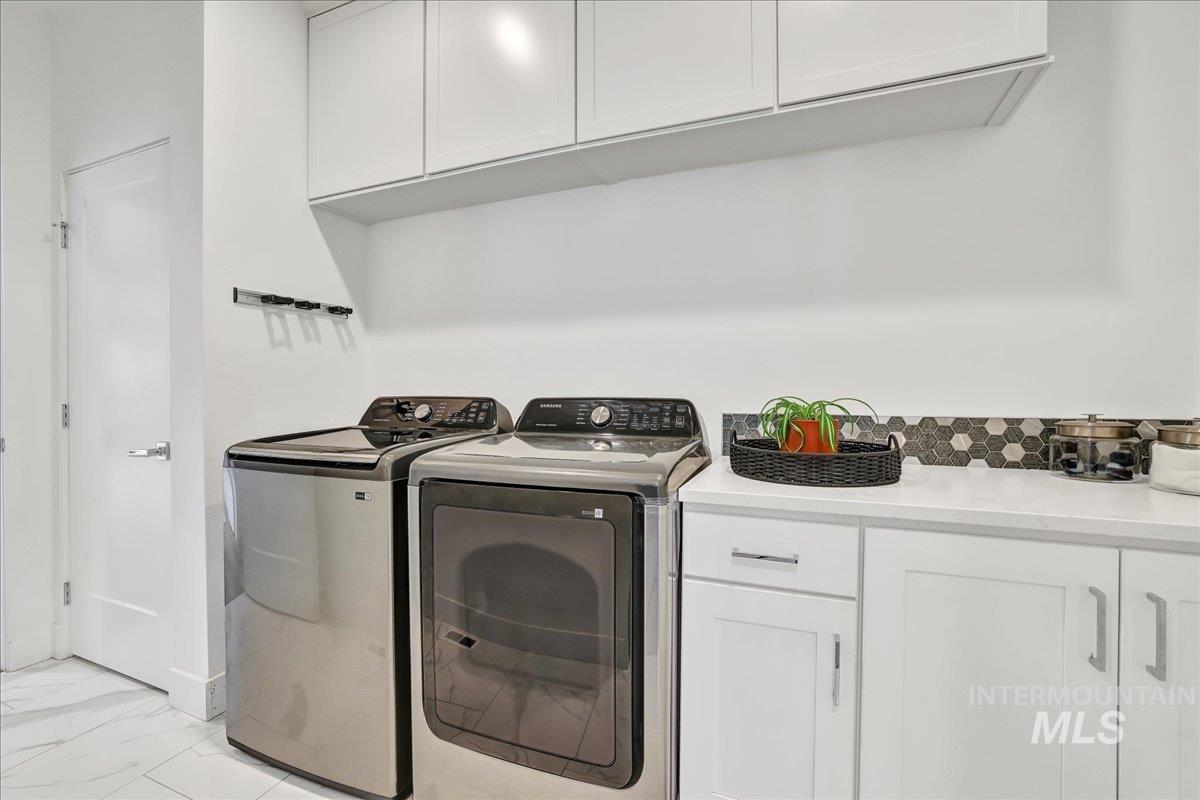 957 Birchton Loop Twin Falls, ID 83301 - Photo 21 of 32 Washroom featuring washing machine and dryer, cabinet space, and light marble finish flooring
