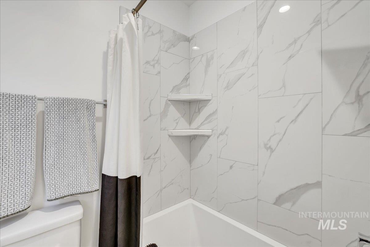 957 Birchton Loop Twin Falls, ID 83301 - Photo 24 of 32 Bathroom featuring shower / bathtub combination with curtain and toilet