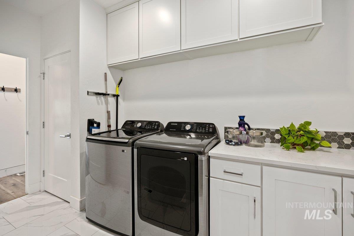 957 Birchton Loop Twin Falls, ID 83301 - Photo 29 of 40 Laundry area featuring cabinet space, light marble finish flooring, and separate washer and dryer