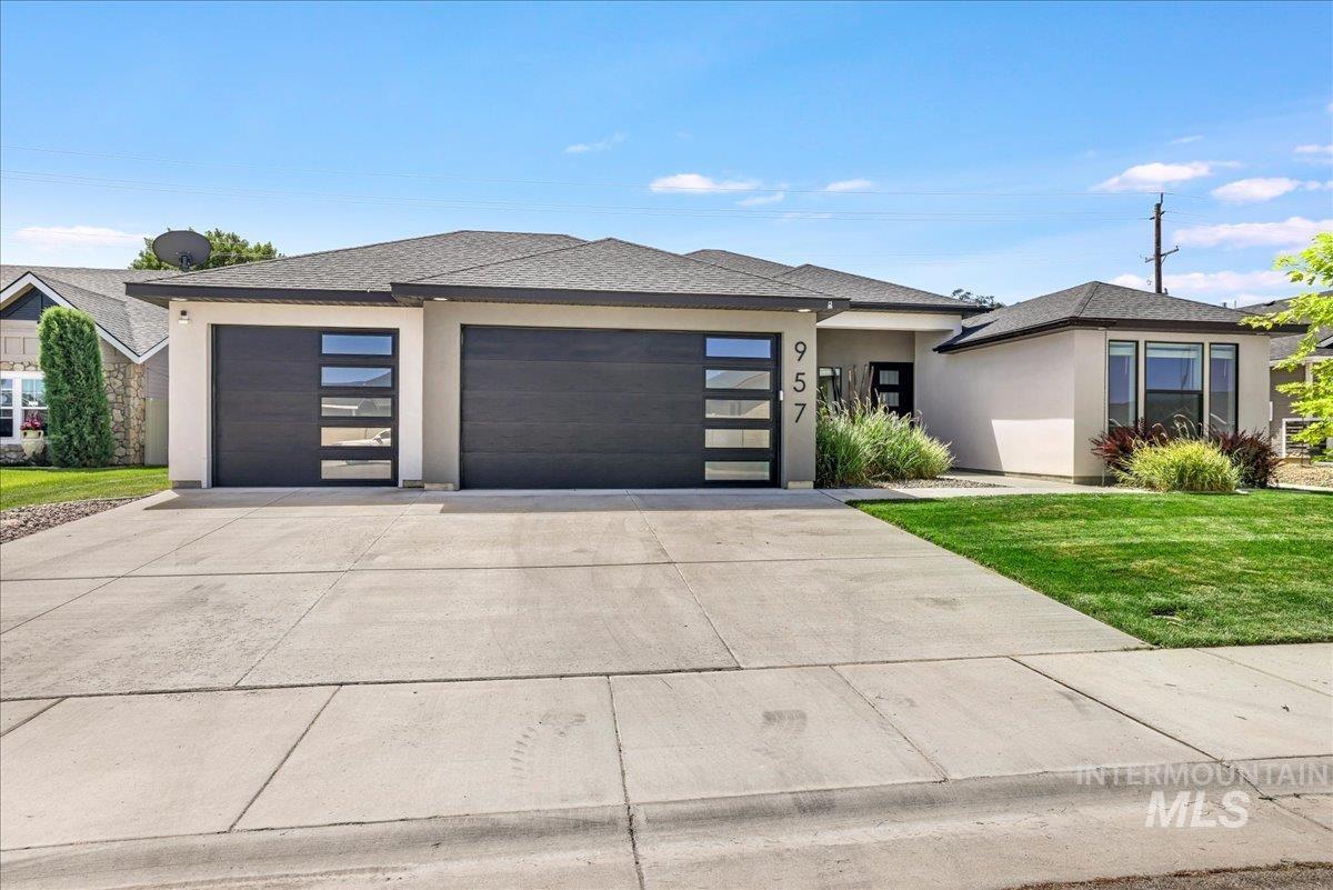 957 Birchton Loop Twin Falls, ID 83301 - Photo 32 of 32 Prairie-style home with stucco siding, a garage, concrete driveway, a shingled roof, and a front lawn