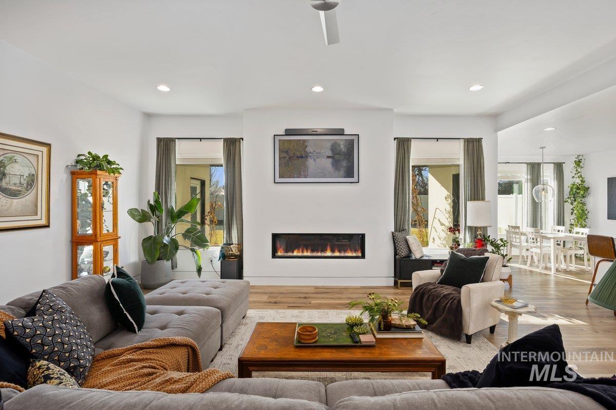 957 Birchton Loop Twin Falls, ID 83301 - Photo 6 of 40 Living area with a glass covered fireplace, wood finished floors, and recessed lighting