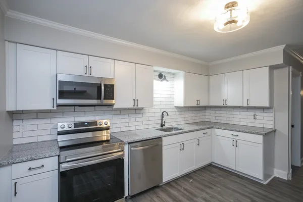 a kitchen with a sink stove and microwave