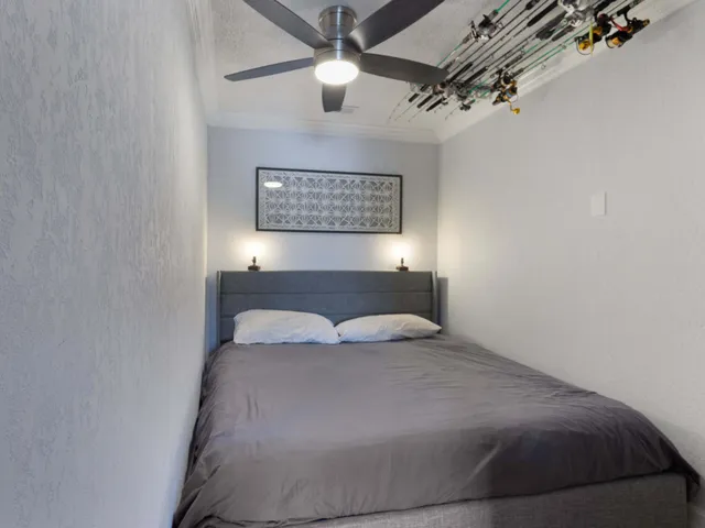 a bedroom with a bed and a lamp on the wall