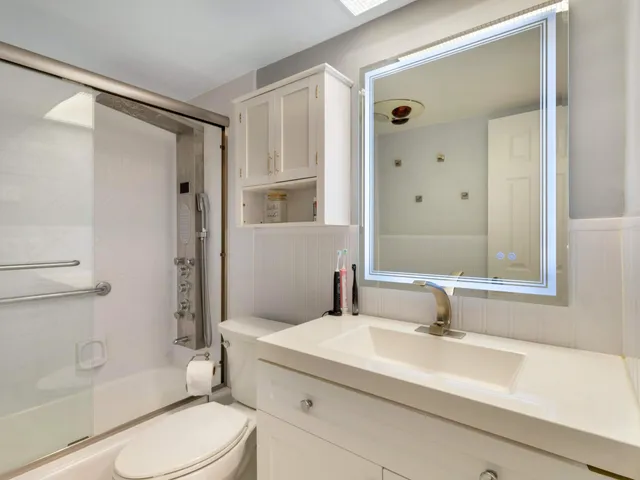 a bathroom with a sink a toilet and shower