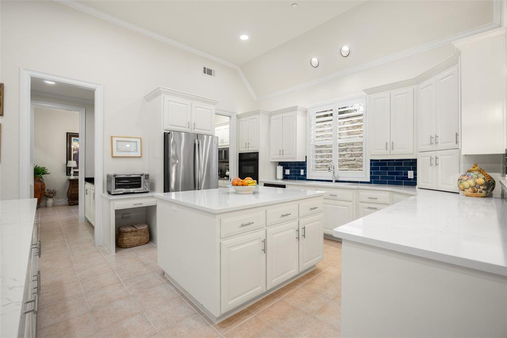 14725 Celestial Place Addison, TX 75254 - Photo 11 of 38 an open white kitchen with center island and stainless steel appliances