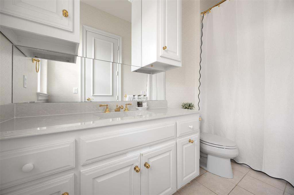 14725 Celestial Place Addison, TX 75254 - Photo 26 of 38 a bathroom with a sink a toilet and a mirror