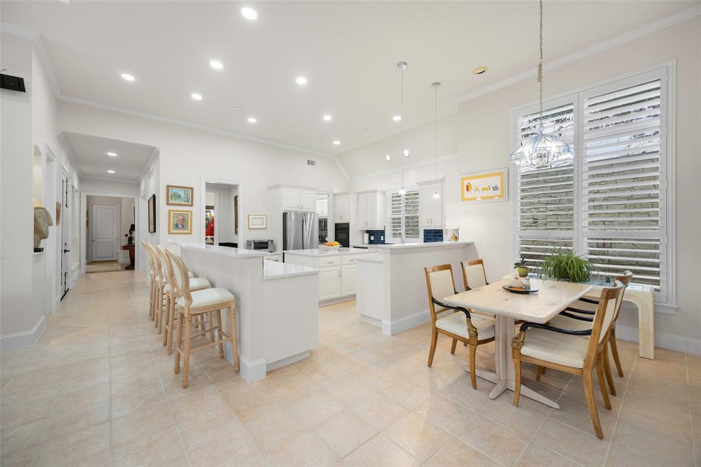 14725 Celestial Place Addison, TX 75254 - Photo 28 of 38 a dining hall with stainless steel appliances kitchen island granite countertop a dining table chairs and a refrigerator