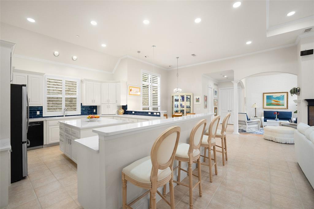 14725 Celestial Place Addison, TX 75254 - Photo 10 of 38 a large kitchen with kitchen island a table and chairs