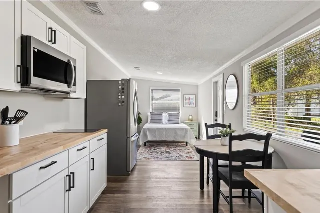 a kitchen with stainless steel appliances granite countertop a kitchen island hardwood floor and a sink