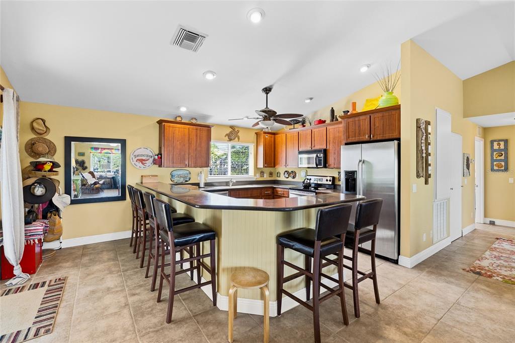 8550 Little Gasparilla Placida, FL 33946 - Photo 16 of 62 a kitchen with stainless steel appliances kitchen island granite countertop a dining table and chairs in it