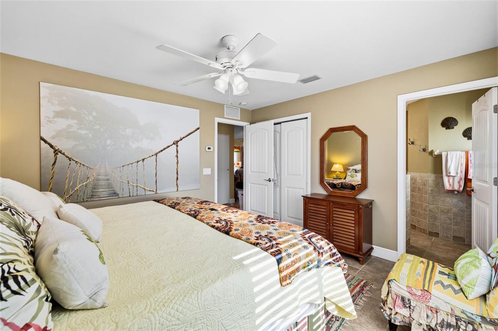 8550 Little Gasparilla Placida, FL 33946 - Photo 27 of 62 a bedroom with a bed a mirror on the dresser and a chandelier