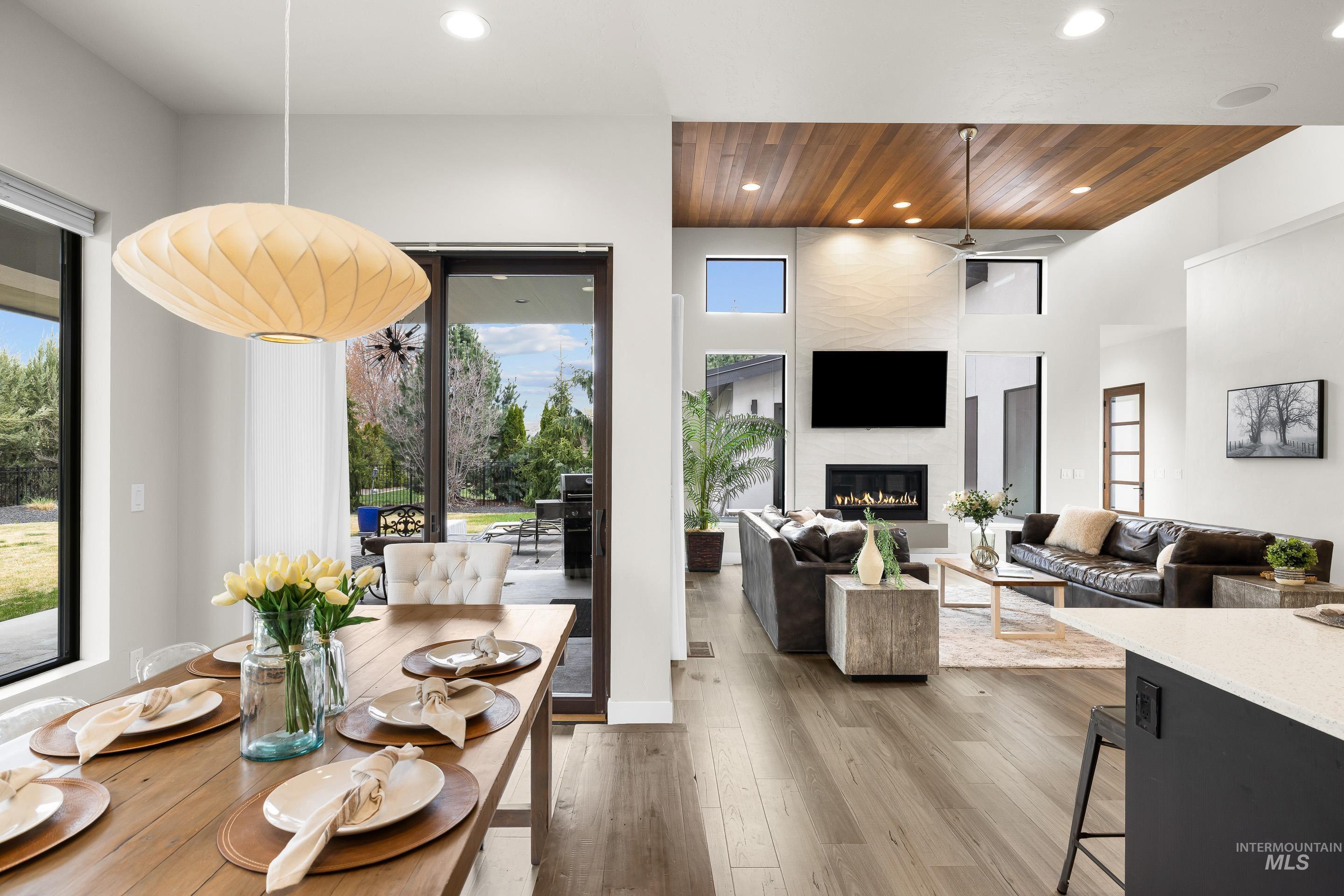 3672 West Red Jade Court Meridian, ID 83646 - Photo 16 of 50 Dining area featuring light wood-style flooring, healthy amount of natural light, recessed lighting, a large fireplace, and a high wood ceiling