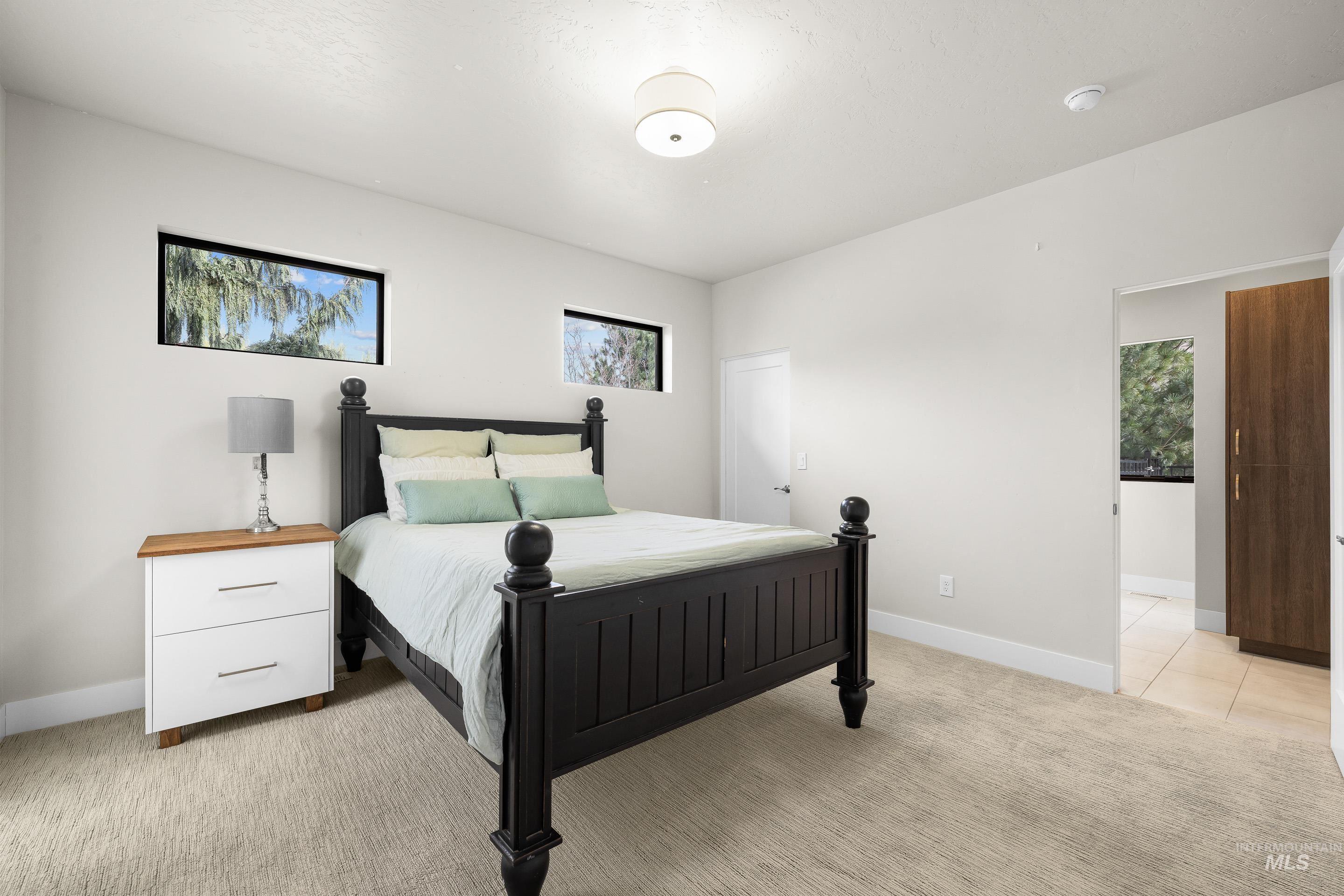 3672 West Red Jade Court Meridian, ID 83646 - Photo 26 of 50 Bedroom with light colored carpet and baseboards