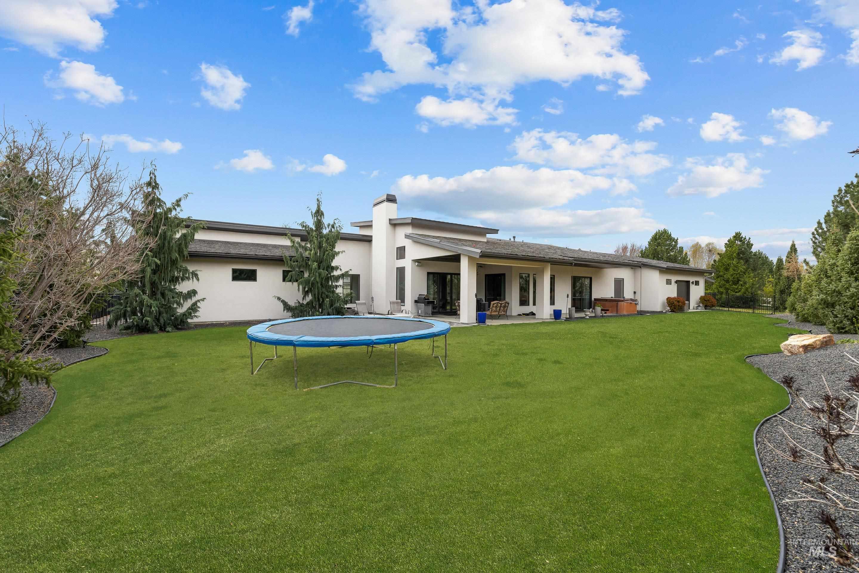 3672 West Red Jade Court Meridian, ID 83646 - Photo 34 of 50 Back of property featuring a patio area, stucco siding, a lawn, and a trampoline