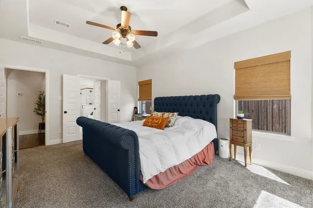a bedroom with a bed and dresser with wooden floor