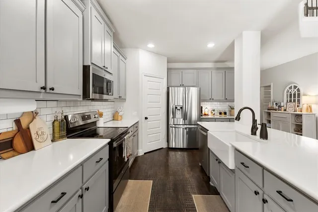 a kitchen with stainless steel appliances granite countertop a sink stove refrigerator and cabinets