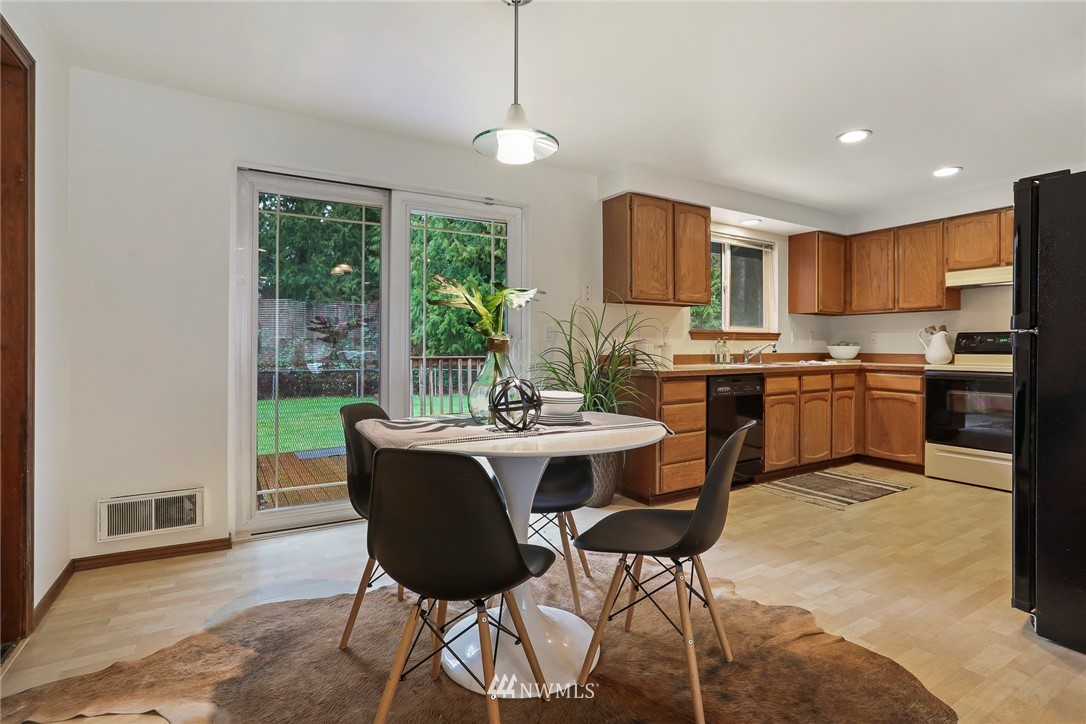 22515 20th Avenue Southeast Bothell, WA 98021 - Photo 7 of 34 a kitchen with a table chairs refrigerator and microwave