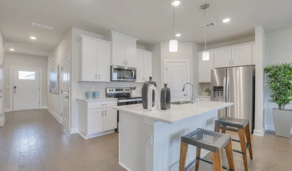 a kitchen with white cabinets and stainless steel appliances