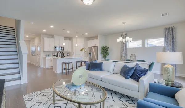 a living room with furniture kitchen and a table