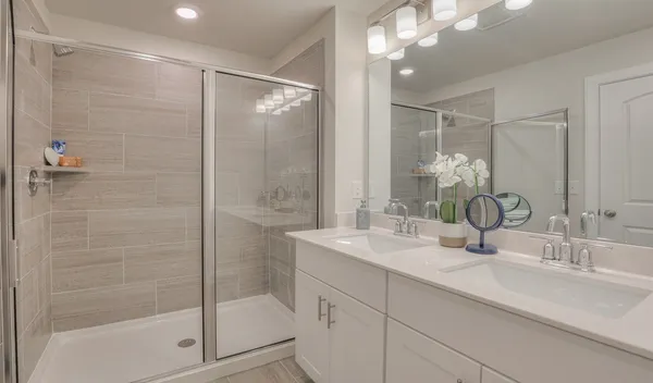 a bathroom with a shower sink vanity granite and mirror
