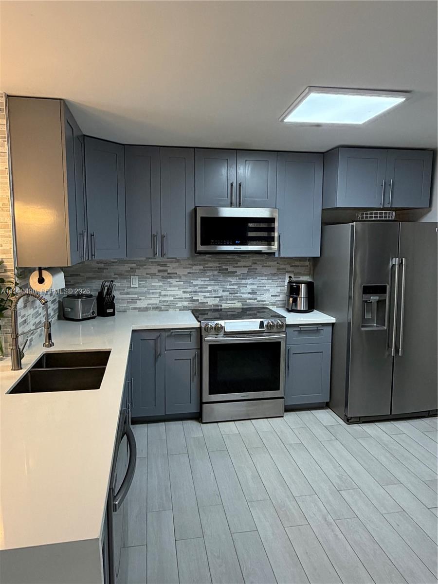 7431 Southwest 163rd Place Miami, FL 33193 - Photo 12 of 18 a kitchen with a refrigerator sink and microwave