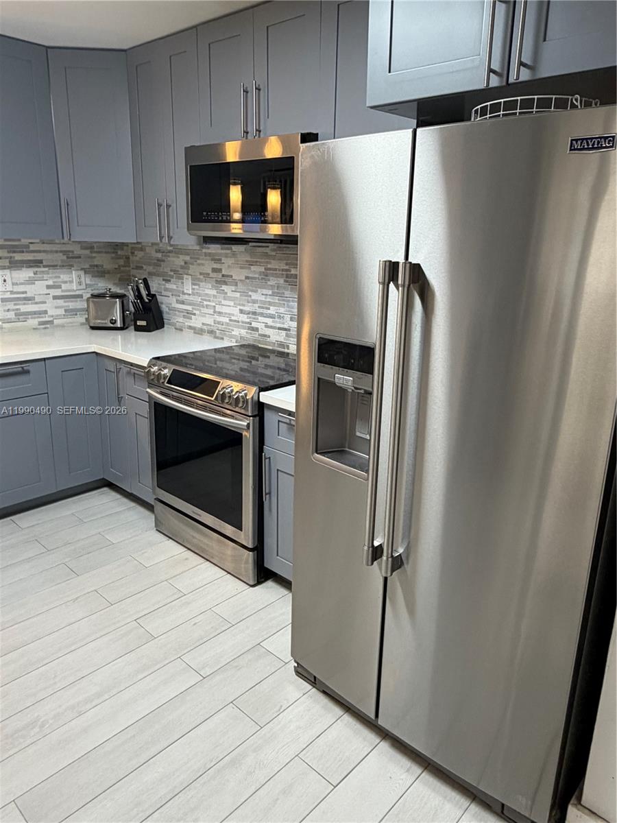 7431 Southwest 163rd Place Miami, FL 33193 - Photo 13 of 18 a kitchen with stainless steel appliances a refrigerator sink and microwave