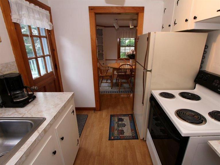 26 Grey Neck Road, Unit 2 West Harwich, MA 02671 - Photo 7 of 19 a kitchen with a refrigerator a stove and a sink with wooden floor
