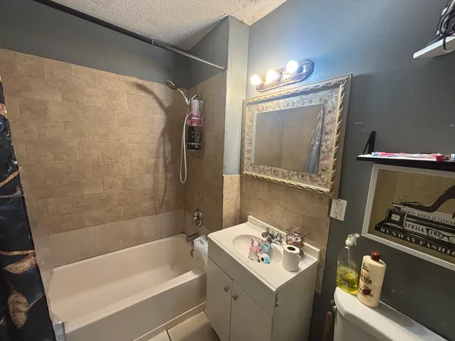 a bathroom with a sink mirror vanity and bathtub