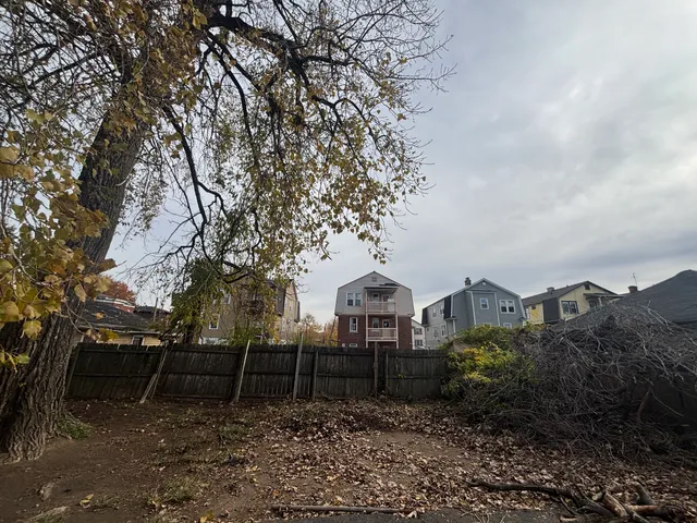 a view of a house with a yard and large trees