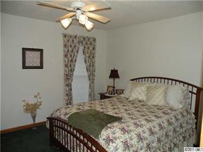 220 Abner Road Stony Point, NC 28678 - Photo 12 of 16 a bedroom with a bed and a chandelier
