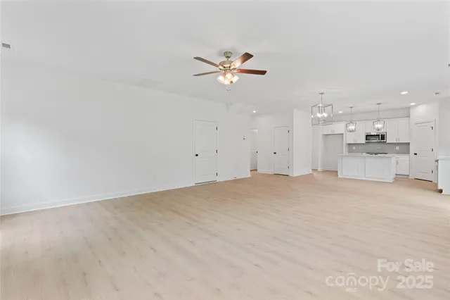 a view of a kitchen with a sink and a chandelier fan