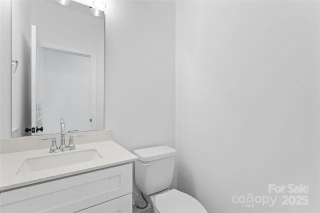 a bathroom with a toilet sink vanity and mirror