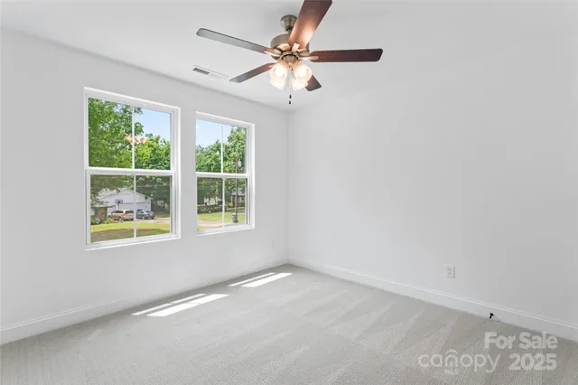 an empty room with a window and a fan