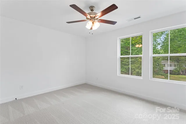an empty room with a window and a fan