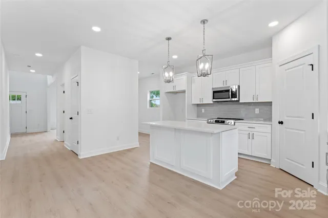 a kitchen with white cabinets and appliances