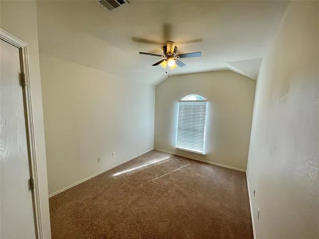 an empty room with a window and a fan