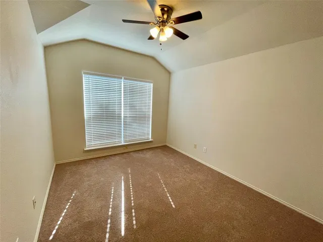 an empty room with a ceiling fan and a window