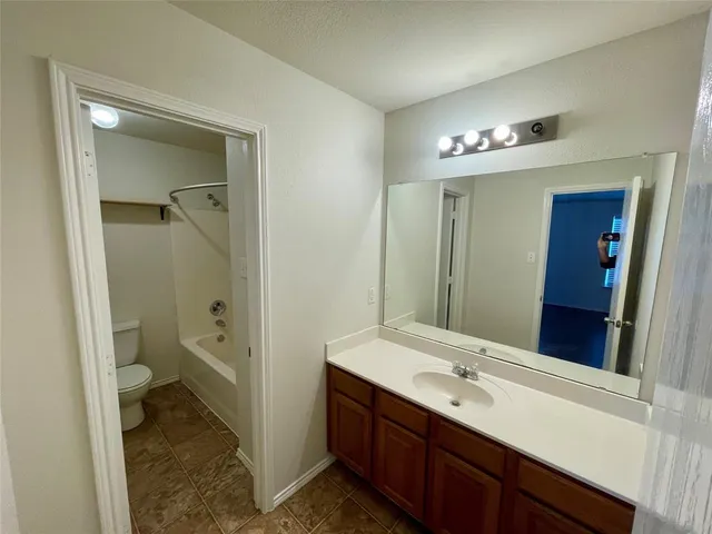 an empty room with closet and a chandelier fan