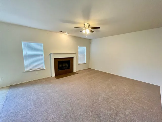 an empty room with a fireplace and fan