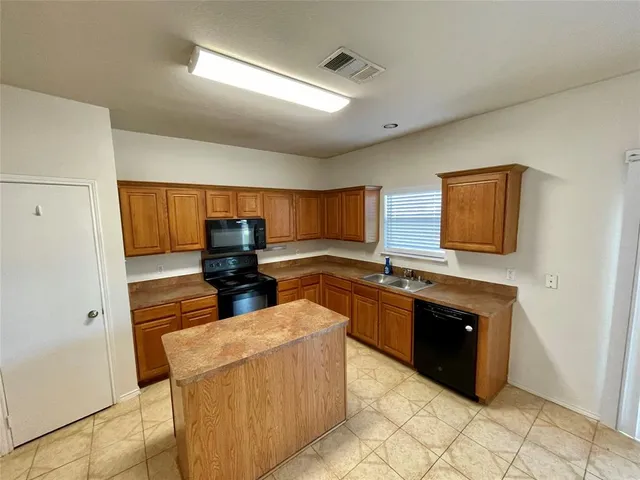 a kitchen with stainless steel appliances granite countertop a stove and a refrigerator