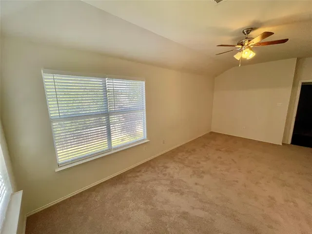 an empty room with windows and fan