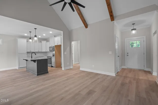 a view of an empty room and kitchen view