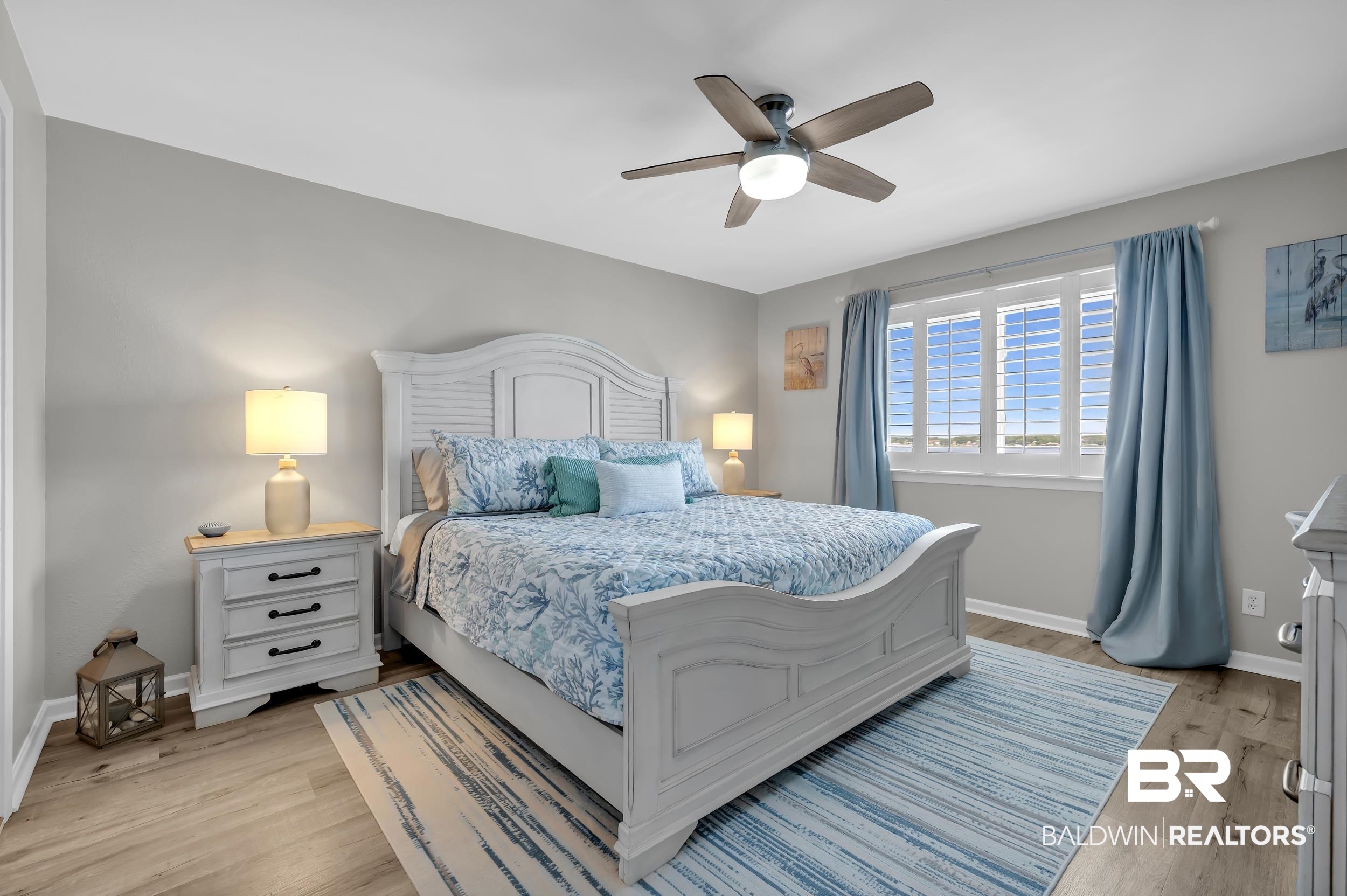 14100 River Road, Unit 211 Pensacola, FL 32507 - Photo 24 of 56 Spacious bedroom featuring wood-finish flooring, light gray wall paint, and a ceiling fan with integrated lighting