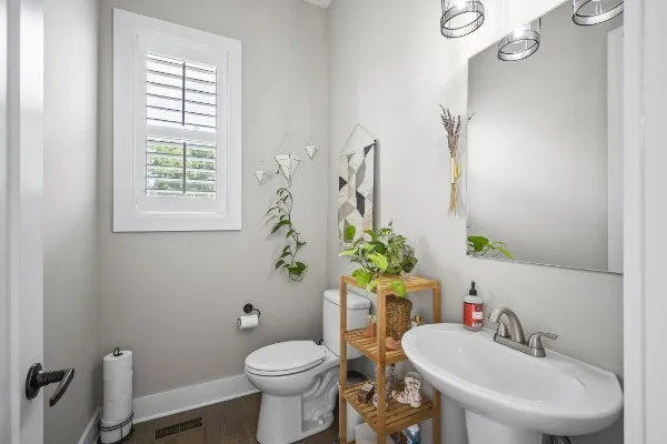a bathroom with a sink toilet and window